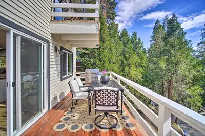 a patio with a table and chairs on a deck at Picturesque Cabin 2 Balconies, Walk to Lake! in Crestline