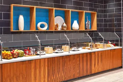 a buffet line with plates and food on display at SpringHill Suites by Marriott Los Angeles Downey in Downey
