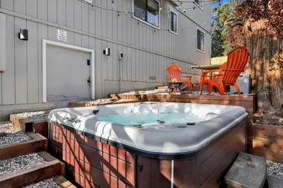 a hot tub with two chairs and a table at Chimney Peak Chalet #2048 by Big Bear Vacations in Big Bear City