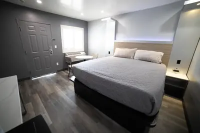 a bedroom with a large bed and a window at Palms Motel in Pico Rivera