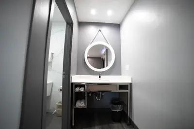 a bathroom with a sink and a mirror at Palms Motel in Pico Rivera