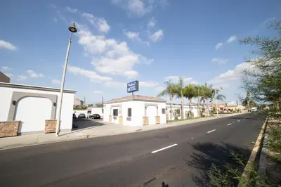 a street with a building on the side of a road at Palms Motel in Pico Rivera