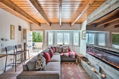 a living room with a couch and a fireplace at Crestline Cabin with Deck 1 Mi to Lake Gregory in Crestline