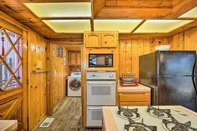 a kitchen with a refrigerator and a stove top oven at Running Springs Cabin with Large Deck and View! in Running Springs