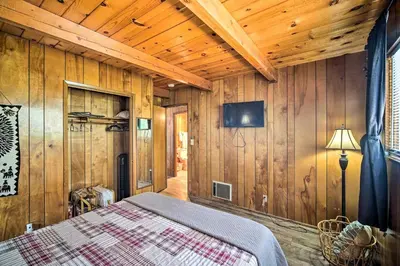 a bedroom with wooden walls and a bed in a room at Running Springs Cabin with Large Deck and View! in Running Springs