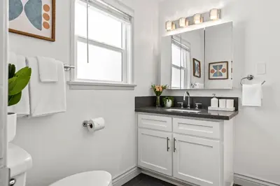 a white bathroom with a sink and a mirror at Spacious Coastal Apartment in a Colorful Community - NRP22-00590 in Long Beach