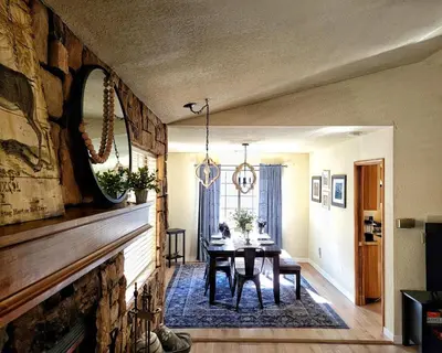 a dining room with a table and a fireplace at Treehouse Cottage in Crestline