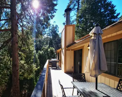 an umbrella sitting on the deck of a house at Treehouse Cottage in Crestline