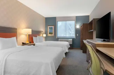 a hotel room with two beds and a flat screen tv at Home2 Suites By Hilton Redlands in Redlands