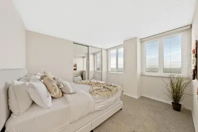 a white bedroom with a bed and a mirror at The tulip Marina Highrise with ocean view in Los Angeles