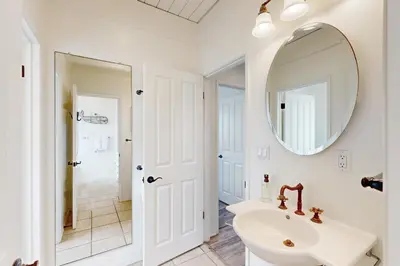 a white bathroom with a sink and a mirror at Brink of Paradise in Carpinteria