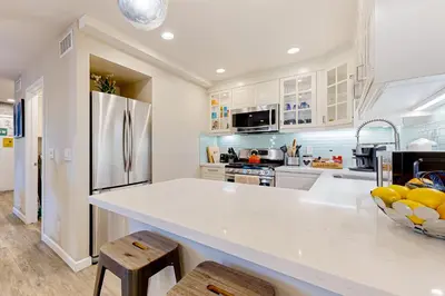 a kitchen with a white counter and a refrigerator at Castles Reach in Anaheim