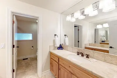 a bathroom with a sink and a large mirror at Bayfront Beauty in Lake Arrowhead