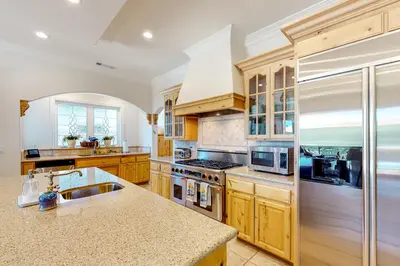 a kitchen with wooden cabinets and a counter top at Bayfront Beauty in Lake Arrowhead
