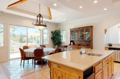 a kitchen with a large island and a table with chairs at Bayfront Beauty in Lake Arrowhead