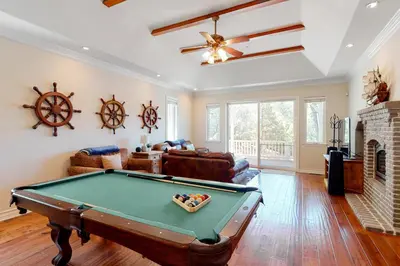 a living room with a pool table and a fireplace at Bayfront Beauty in Lake Arrowhead