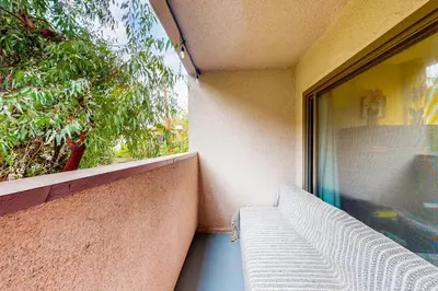 a balcony with a white bench next to a window at Pacific Cove Unit 111 in Los Angeles