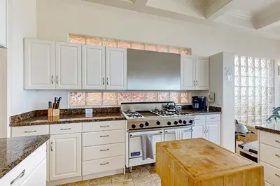 a kitchen with white cabinets and a stove top oven at Breakers Way Dream in Carpinteria