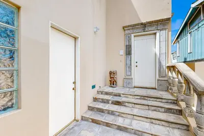 a set of stairs leading to a white door at Breakers Way Dream in Carpinteria
