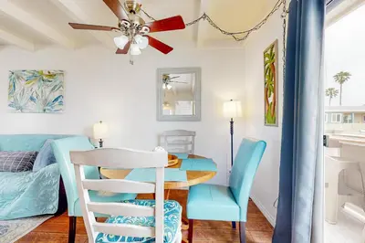 a dining room with a table and blue chairs at Sailaway Cabin B in Ventura