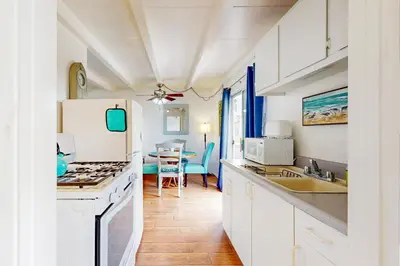 a kitchen with white appliances and a dining room at Sailaway Cabin B in Ventura