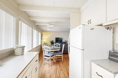 a kitchen with a table and a white refrigerator at Sailaway Cabin in Ventura
