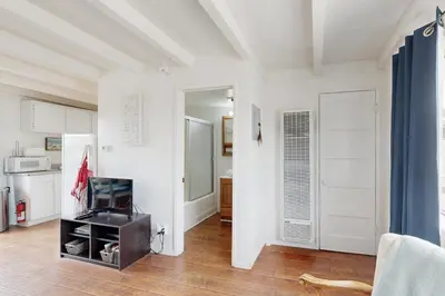 a kitchen with white walls and a room with a door at Sailaway Cabin in Ventura