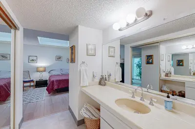 a bathroom with a sink and a mirror and a bedroom at Gateshead Haven in Oxnard