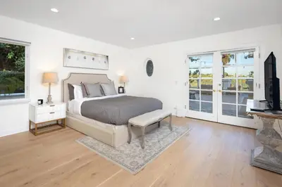 a bedroom with a bed and a tv and windows at Stradella Spanish in Los Angeles