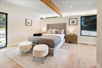 a bedroom with a large bed and two chairs at Sea Vista in Malibu