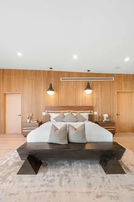 a bedroom with a large white bed and wooden walls at Sea Vista in Malibu