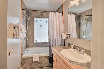 a bathroom with a sink and a tub and a mirror at Cozy Skyforest Cabin about 1 Mi to Lake Arrowhead! in Skyforest