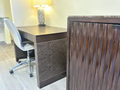 a desk with a chair and a table with a lamp at The Crest Motel in Corona