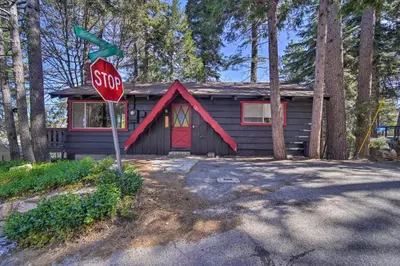 a stop sign in front of a small house at Newly Renovated Lake Arrowhead Cabin with Deck! in Lake Arrowhead