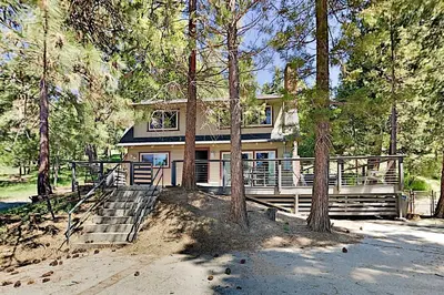 a house in the middle of a forest with trees at Serene Cabin in Lake Arrowhead