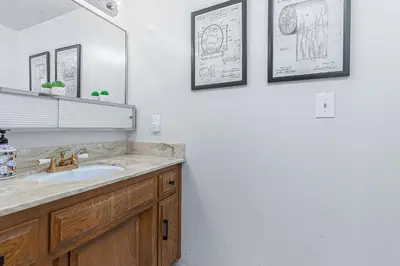 a bathroom with a sink and two drawings on the wall at Serene Cabin in Lake Arrowhead