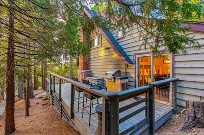 a house with a large porch with a deck at Serene Cabin in Lake Arrowhead