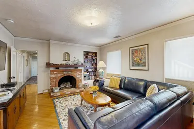 a living room with a leather couch and a fireplace at Cedar Oasis in Ventura