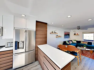 a kitchen and living room with a refrigerator and a table at Hale I'a in Carpinteria