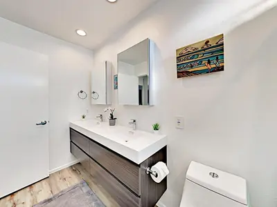 a bathroom with a sink and a toilet and a mirror at Hale I'a in Carpinteria