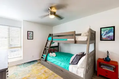 a bedroom with two bunk beds and a ceiling fan at Hale I'a in Carpinteria