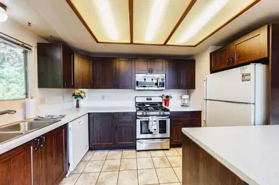 a kitchen with wooden cabinets and a white refrigerator at Dragon's Lair in Lake Arrowhead