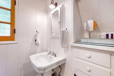 a white bathroom with a sink and a mirror at Hideaway Pines in Lake Arrowhead