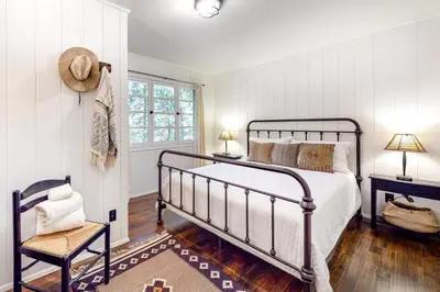 a bedroom with a bed and a chair and a window at Hideaway Pines in Lake Arrowhead