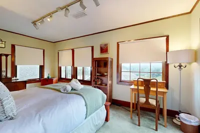 a bedroom with a bed and a desk and windows at Highland Park Haven in Los Angeles