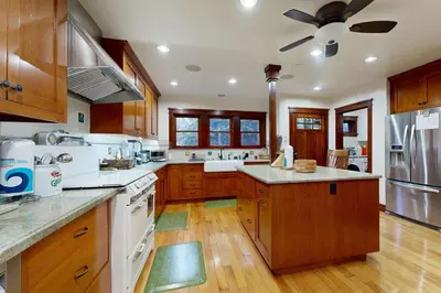 a large kitchen with wooden cabinets and a ceiling fan at Highland Park Haven in Los Angeles
