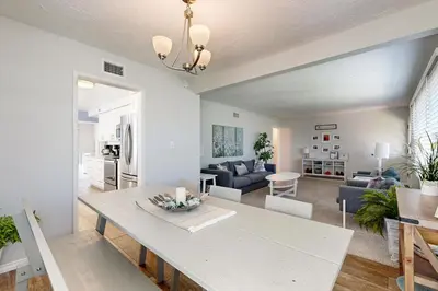 a living room with a table and a dining room at Evening Oasis in Orange