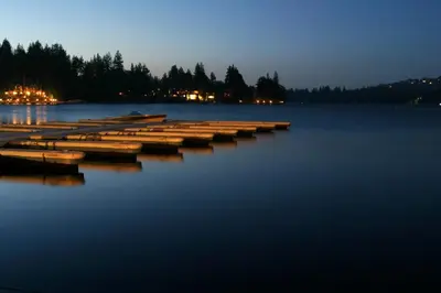 a group of boats sitting in the water at night at Tree-Top Getaway in Lake Arrowhead