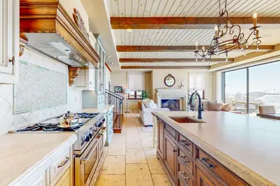 a large kitchen with a counter top and a living room at Breakers Way Adventure in Carpinteria
