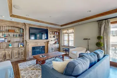 a living room with a blue couch and a fireplace at Breakers Way Adventure in Carpinteria